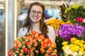 Flower seller, young woman standing at shop with flower in hands Royalty Free Stock Photo