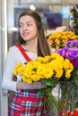 Flower seller, young woman standing at shop with flower in hands Royalty Free Stock Photo