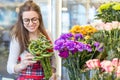 Flower seller, young woman standing at shop with flower in hands Royalty Free Stock Photo