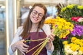 Flower seller, young woman standing at shop with flower in hands Royalty Free Stock Photo