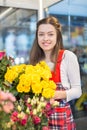 Flower seller, young woman standing at shop with flower in hands Royalty Free Stock Photo