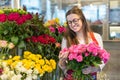 Flower seller, young woman standing at shop with flower in hands Royalty Free Stock Photo