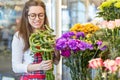 Flower seller, young woman standing at shop with flower in hands Royalty Free Stock Photo