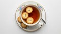 Flower shaped biscuits float in the tea while more biscuits rest on the Royalty Free Stock Photo