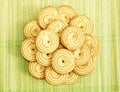 Orange beige colour bright cookies are arranged like a flower on a green yellow beach mat