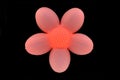 Flower shaped lamp shining pink light in the dark.