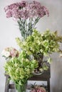 Flower shop concept. Different varieties fresh spring flowers on wooden chair table. Bouquets on shelf, florist business. Royalty Free Stock Photo