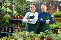 in flower store, women seller wait for customers to help pick up undemanding plant