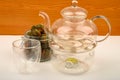 Flower tea balls in a glass jar, a glass teapot and a glass on a white background. Close up Royalty Free Stock Photo