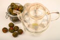 Flower tea balls in a glass jar and a glass teapot on a white background. Close up Royalty Free Stock Photo