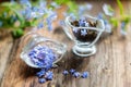 flower tea and a bouquet of forget-me-nots on a wooden background
