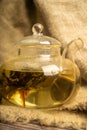 Flower tea brewed in a glass teapot on a background of homespun fabric with a rough texture. Close up Royalty Free Stock Photo