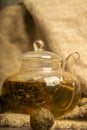 Flower tea brewed in a glass teapot on a background of homespun fabric with a rough texture. Close up. Royalty Free Stock Photo