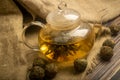 Flower tea brewed in a glass teapot on a background of homespun fabric with a rough texture. Close up Royalty Free Stock Photo