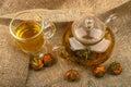 Flower tea brewed in a glass teapot, a glass of tea and balls of flower tea on a background of rough homespun fabric. Close up Royalty Free Stock Photo