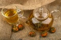 Flower tea brewed in a glass teapot, a glass of tea and balls of flower tea on a background of rough homespun fabric. Close up Royalty Free Stock Photo