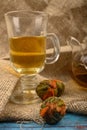 Flower tea brewed in a glass teapot, a glass of flower tea and balls of flower tea on a background of rough homespun fabric. Close Royalty Free Stock Photo