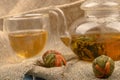 Flower tea brewed in a glass teapot, a glass of tea and balls of flower tea on a background of rough homespun fabric. Close up Royalty Free Stock Photo