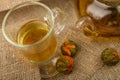 Flower tea brewed in a glass teapot, a glass of tea and balls of flower tea on a background of rough homespun fabric. Close up Royalty Free Stock Photo