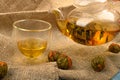Flower tea brewed in a glass teapot, a glass of tea and balls of flower tea on a background of rough homespun fabric. Close up Royalty Free Stock Photo