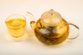Flower tea brewed in a glass teapot and a glass of tea on a white background. Close up Royalty Free Stock Photo