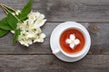 Flower tea from jasmine. A cup on wooden table.