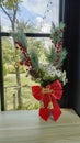 Flower vase decorated with red ribbon on Christmas Day