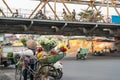 Flower vendor on Hanoi street at early morning with Long Bien old metal bridge on background Royalty Free Stock Photo
