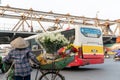 Flower vendor on Hanoi street at early morning with Long Bien old metal bridge on background Royalty Free Stock Photo