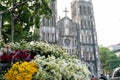 Flower vendor on Hanoi street at early morning with St. Joseph Cathedral church on background Royalty Free Stock Photo