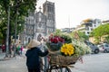 Flower vendor on Hanoi street at early morning with St. Joseph Cathedral church on background Royalty Free Stock Photo