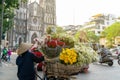 Flower vendor on Hanoi street at early morning with St. Joseph Cathedral church on background Royalty Free Stock Photo