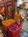 A flower vendor smiling and looking at the camera at Dadar flower market, Mumbai
