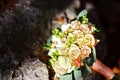 Flower wedding bouquet of white and pink flowers with gold wedding rings of brides, on the rocks Royalty Free Stock Photo
