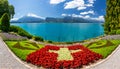 Flowerbed of the Swiss flag with boat cruise on the Thun lake and Alps mountains, Oberhofen, Switzerland. Swiss flag made of Royalty Free Stock Photo