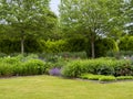 Flowerbeds and a green lawn in a summer garden