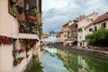 Flowered balconies at ancient buildings over a river, France