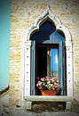 flowered balcony with a window in the house and many flower pots Royalty Free Stock Photo