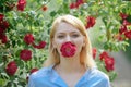 Flowering beauty. Adorable girl with flower bloom. Pretty girl at blossoming rose bush. girl with red flowers in Royalty Free Stock Photo