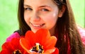 Flowering in spring. Cute girl child with red tulip flowers in spring day. Pretty girl with flower bouquet. Little girl