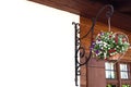 A flowerpot in the shape of a heart hangs on a forged holder on a wooden house Royalty Free Stock Photo