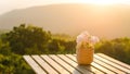 Flowerpot on wooden table on outdoor terrace. Beautiful seating with landscape mountains view while sunset Royalty Free Stock Photo