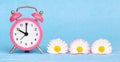 Flowers and alarm clock, spring or daylight savings time banner Royalty Free Stock Photo