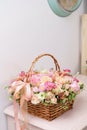 Flowers arrangement with various of colors in wicker basket on pink table. beautiful spring bouquet. bright room, white Royalty Free Stock Photo