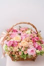 Flowers arrangement with various of colors in wicker basket on pink table. beautiful spring bouquet. bright room, white Royalty Free Stock Photo