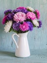 Flowers asters in white enameled pitcher