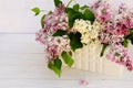 Flowers background. Bouquet of a branch of lilac spring flowers on a white wooden background. Royalty Free Stock Photo