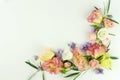 Flowers background. Frame wreath of green eucalyptus branches and pink roses and purple flowers on white background Royalty Free Stock Photo