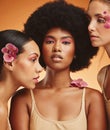 Flowers, beauty and portrait of women with makeup standing in a studio with an orange background. Skincare, diversity