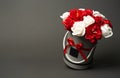 Flowers in bloom: A bouquet of red and white roses in a gray round box on a gray background.
